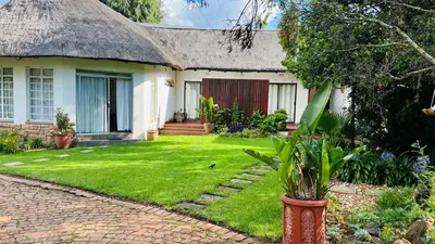a house with a grass yard in front of it at Midrand Manor Guesthouse in Midrand