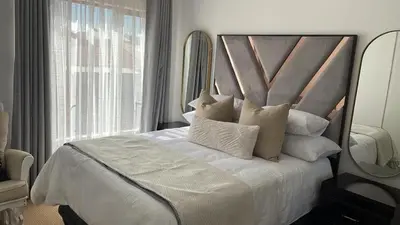 a bedroom with a white bed with a large mirror at The House of Cataleya in Midrand