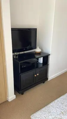 a black entertainment center with a flat screen tv at The House of Cataleya in Midrand