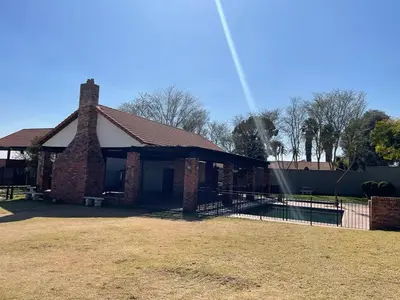 a brick house with a chimney and a fence at The House of Cataleya in Midrand