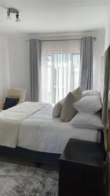 a bedroom with a bed with pillows and a window at The House of Cataleya in Midrand