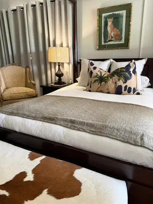 a bedroom with a large bed and a chair at Private African Retreat at 3000ha Mangweni Game Reserve in Elandsbosch