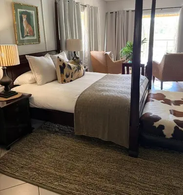 a bedroom with a bed and a table and chairs at Private African Retreat at 3000ha Mangweni Game Reserve in Elandsbosch