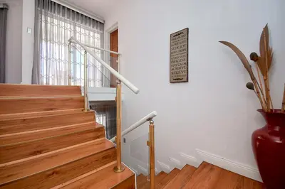 a staircase with wooden steps and a sign on the wall at GlenAustin Garden Haven in Midrand