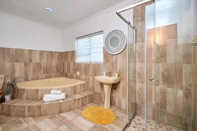 a bathroom with a tub and a sink and a shower at GlenAustin Garden Haven in Midrand