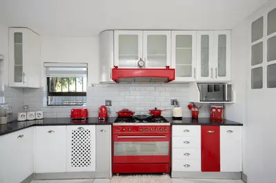 a kitchen with red appliances and white cabinets at GlenAustin Garden Haven in Midrand