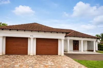 a house with two garage doors in a driveway at XNZN Guest House in Tzaneen