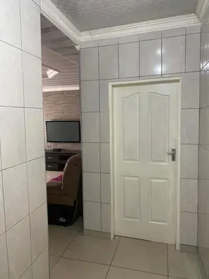 a room with a door and a couch and a television at XNZN Guest House in Tzaneen