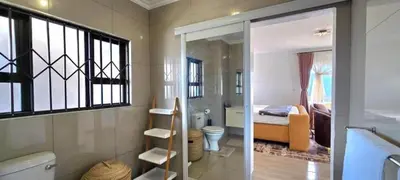 a bathroom with a toilet and a bedroom with a bed at Penthouse Menlyn in Pretoria