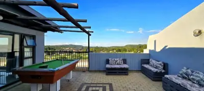 a patio with a pool table and two chairs at Penthouse Menlyn in Pretoria