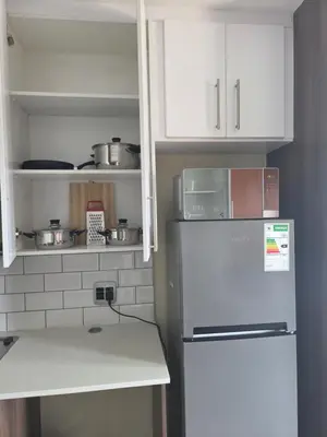 a kitchen with a refrigerator and white cabinets at Bachelor in Hatfield in Pretoria