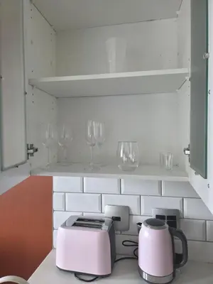 a kitchen with a toaster and wine glasses on a shelf at Bachelor in Hatfield in Pretoria