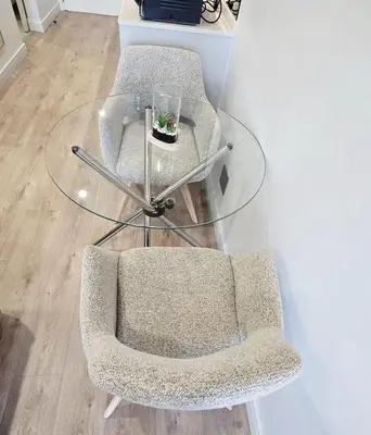 two chairs and a glass table in a room at Serenity Escape at Ellipse Waterfall in Midrand