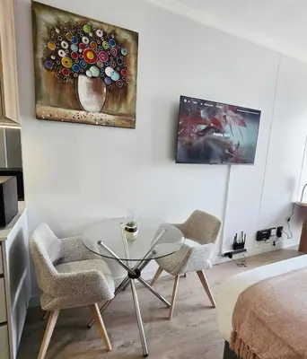 a living room with a glass table and two chairs at Serenity Escape at Ellipse Waterfall in Midrand