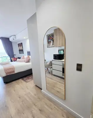 a bedroom with a mirror and a bed and a desk at Serenity Escape at Ellipse Waterfall in Midrand