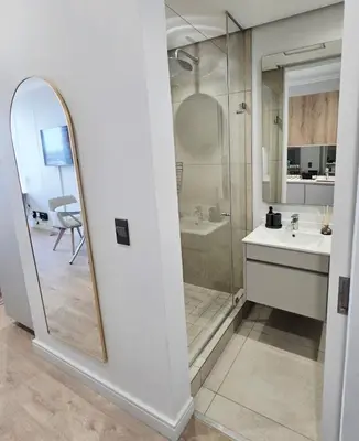 a bathroom with a shower and a sink and a mirror at Serenity Escape at Ellipse Waterfall in Midrand