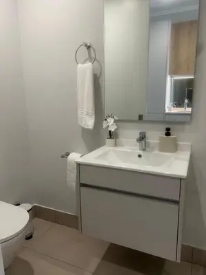 a white bathroom with a sink and a toilet at Executive Studio at Ellipse Galileo - Waterfall in Midrand