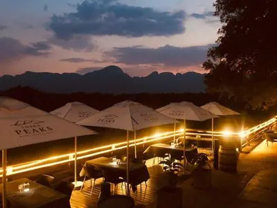 a group of tables with umbrellas at night at House 110 in Hoedspruit
