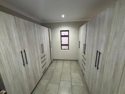 a hallway with wooden cabinets and a window at House 110 in Hoedspruit