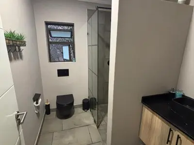 a bathroom with a glass shower and a sink at House 110 in Hoedspruit