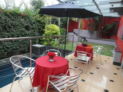 a patio with two tables and an umbrella at Red Square Home in Pretoria