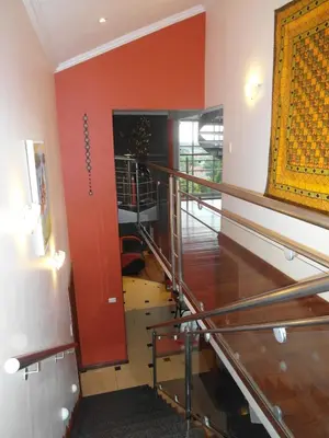 a staircase in a room with a red wall at Red Square Home in Pretoria