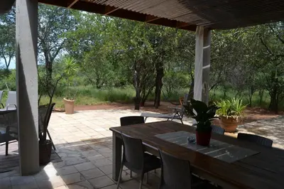 a wooden table and chairs on a patio at Africana Properties Impala Private Villa in Hoedspruit