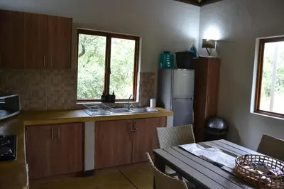a kitchen with a table and a sink and a refrigerator at Africana Properties Impala Private Villa in Hoedspruit