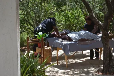 a woman laying in a bed with a man in it at Africana Properties Impala Private Villa in Hoedspruit