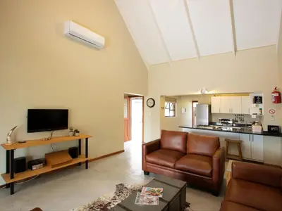 a living room with a couch and a television at Africana Properties The Village 25 in Hoedspruit