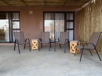a group of chairs and tables on a patio at Africana Properties The Village 25 in Hoedspruit