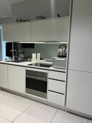 a white kitchen with a stove and a microwave at Mabiyela at Ellipse Waterfall in Midrand