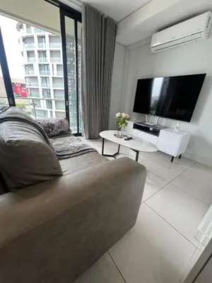 a living room with a couch and a tv at Mabiyela at Ellipse Waterfall in Midrand