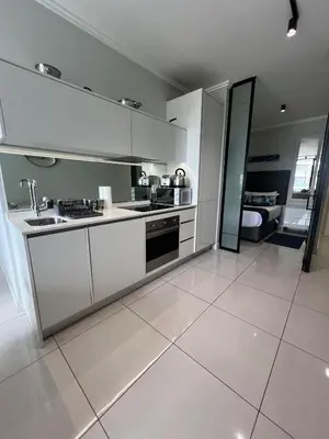 a large kitchen with white cabinets and appliances at Mabiyela at Ellipse Waterfall in Midrand