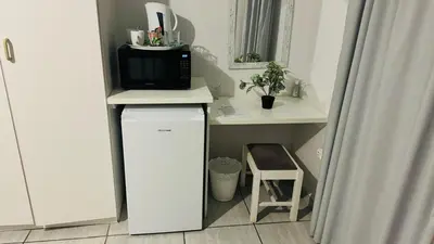 a kitchen with a microwave and a small refrigerator at UrbanStay in Pretoria