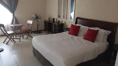 a bedroom with a large white bed with red pillows at UrbanStay in Pretoria