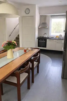 a kitchen with a wooden table with chairs and a sink at UrbanStay in Pretoria
