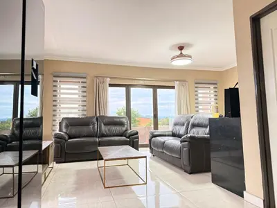 a living room with two leather couches and a table at Dunamis Lodge in Giyani