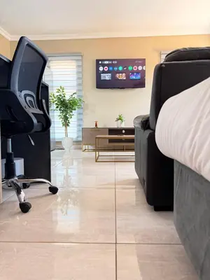 a bedroom with a bed and a chair and a tv at Dunamis Lodge in Giyani