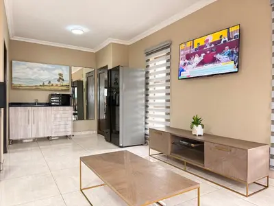 a living room with a tv on the wall at Dunamis Lodge in Giyani