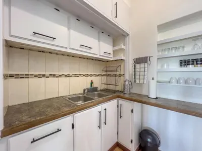 a kitchen with white cabinets and a sink at Donovan Heights 35 in Midrand