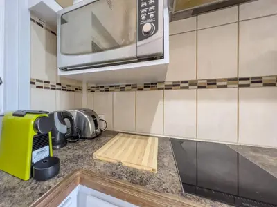 a kitchen with a microwave and a wooden cutting board at Donovan Heights 35 in Midrand