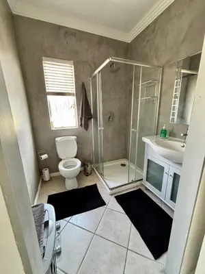 a bathroom with a shower and a toilet and a sink at Donovan Heights 35 in Midrand