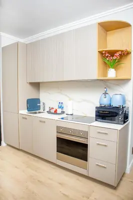 a kitchen with white cabinets and a stove at Ellipse Waterfall Premium Apartments - Blue in Johannesburg