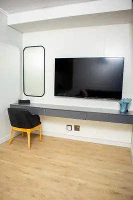 a living room with a large television on a wall at Ellipse Waterfall Premium Apartments - Cream in Johannesburg