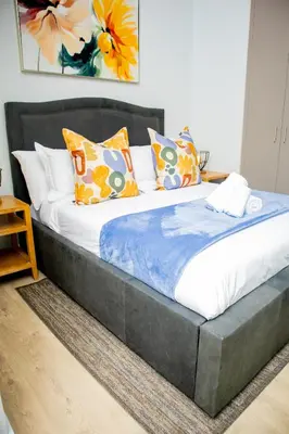 a large bed with pillows on it in a room at Ellipse Waterfall Premium Apartments - Cream in Johannesburg