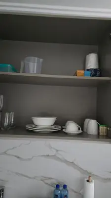 a shelf with plates and bowls on it at Ellipse Waterfall Premium Apartments - Cream in Johannesburg
