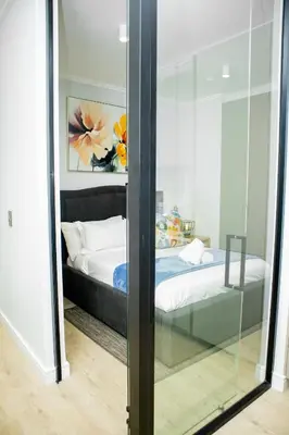a reflection of a bedroom with a bed in a mirror at Ellipse Waterfall Premium Apartments - Cream in Johannesburg