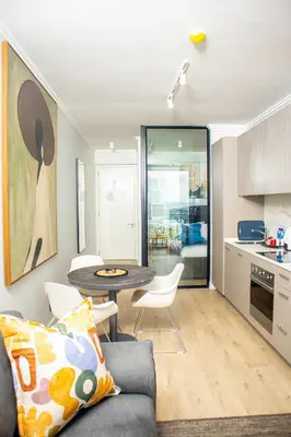 a living room with a couch and a table in a kitchen at Ellipse Waterfall Premium Apartments - Cream in Johannesburg