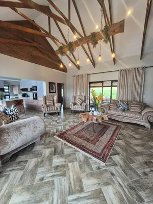a large living room with couches and a rug at Highland Gate 948 in Dullstroom